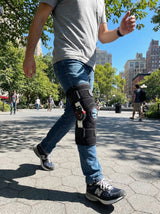 Woman wearing Flexa Hinged Brace walking outdoors, lifestyle scene with structured knee support